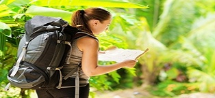 woman by herself walking through terrain looking at map