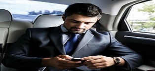 business man in taxi looking at cell phone