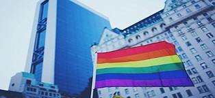 LGBTQ flag flying in front of office buildings