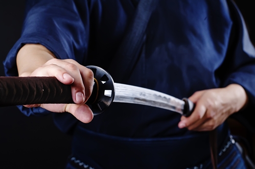 man drawing samurai sword