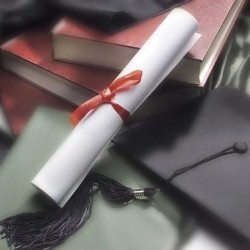 college diploma laying on cap and gown